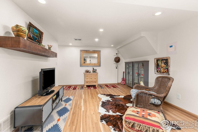 living room with recessed lighting, visible vents, light wood-style flooring, and baseboards