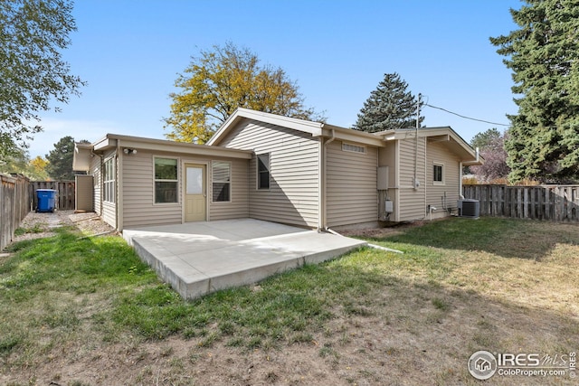 rear view of house featuring a patio area, a fenced backyard, central AC, and a yard