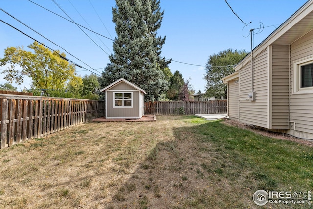 view of yard featuring a storage shed, an outdoor structure, and a fenced backyard