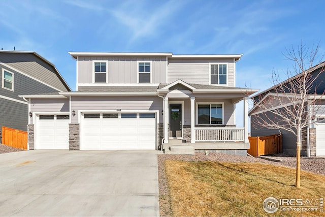 view of front of home featuring a porch, a garage, concrete driveway, stone siding, and board and batten siding