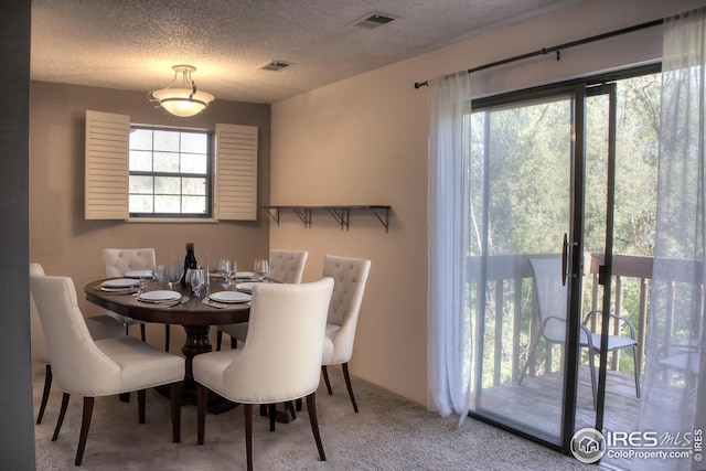 dining space with carpet, visible vents, and plenty of natural light