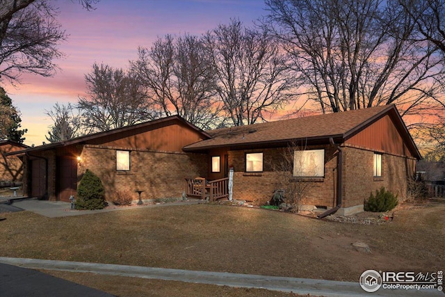 view of front of property featuring a yard and brick siding