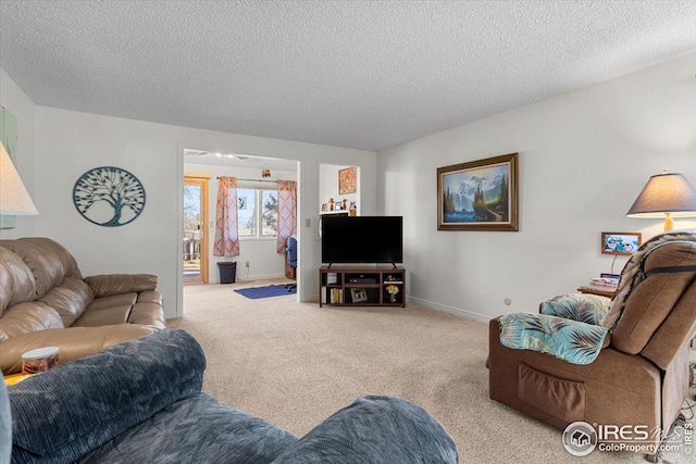 carpeted living area with baseboards and a textured ceiling