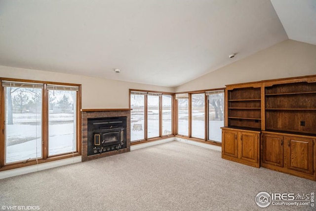 unfurnished living room featuring vaulted ceiling and light colored carpet