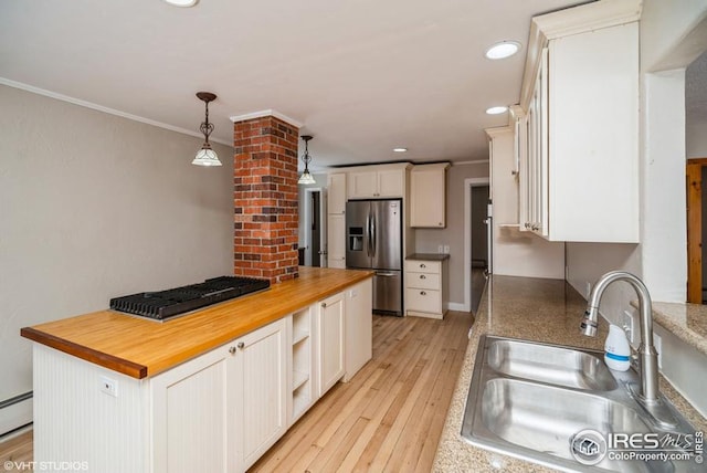 kitchen with ornamental molding, white cabinetry, a sink, butcher block countertops, and stainless steel fridge with ice dispenser