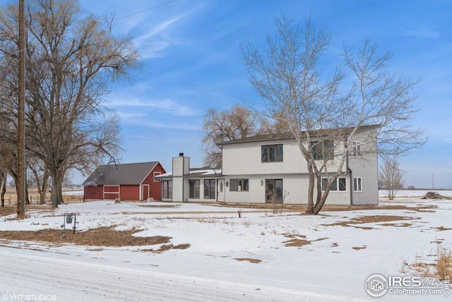 view of front of property with a detached garage and a chimney