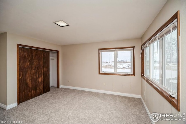 unfurnished bedroom with a closet, carpet flooring, and baseboards