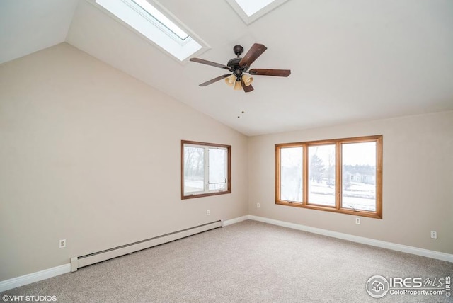 carpeted spare room featuring a baseboard heating unit, lofted ceiling with skylight, a ceiling fan, and baseboards