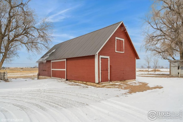 snow covered garage with a detached garage