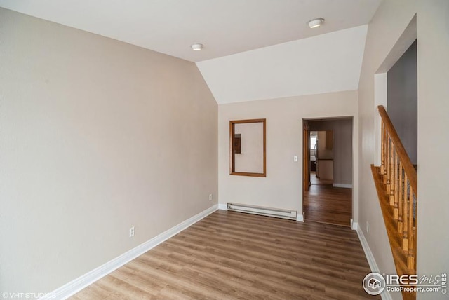 unfurnished room with wood finished floors, baseboards, vaulted ceiling, stairs, and baseboard heating