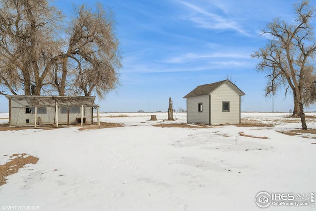 yard covered in snow featuring an outbuilding