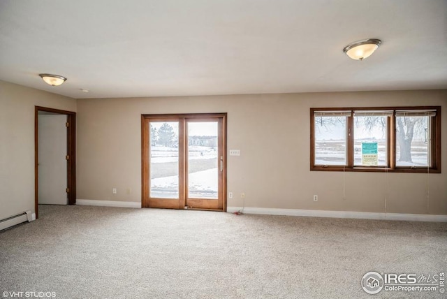 carpeted empty room featuring baseboards