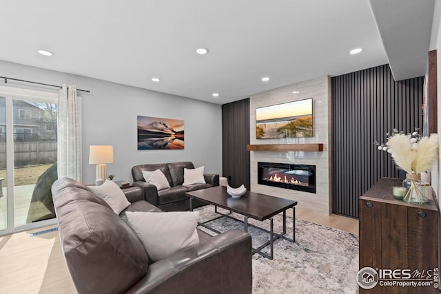 living room with recessed lighting, a fireplace, and wood finished floors