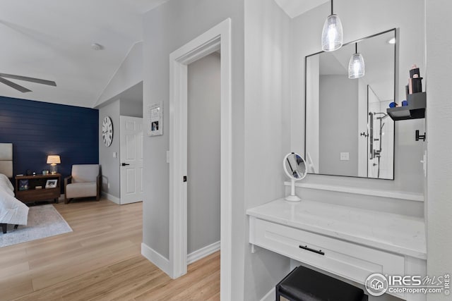 bathroom featuring lofted ceiling, baseboards, a ceiling fan, and wood finished floors