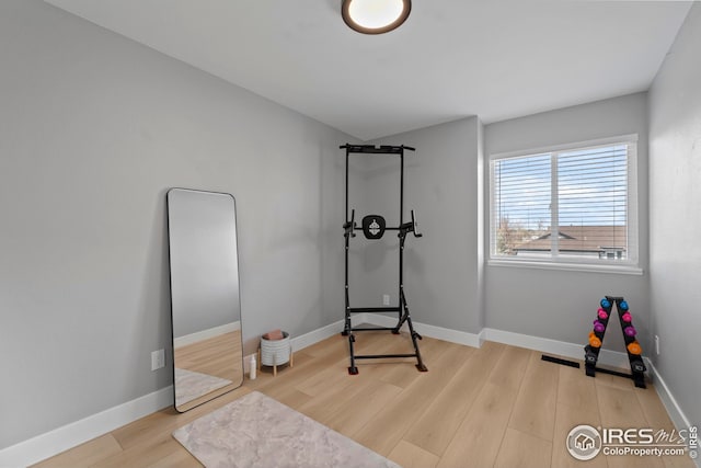 workout area featuring wood finished floors and baseboards