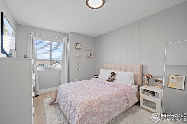 bedroom featuring light wood-style flooring and baseboards