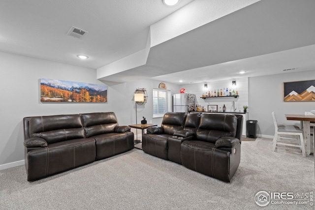 carpeted living room featuring recessed lighting, visible vents, a bar, and baseboards