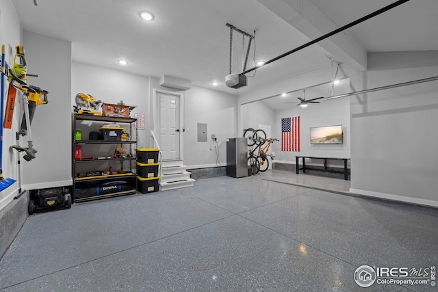 garage featuring baseboards, electric panel, and a garage door opener