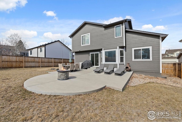 back of property featuring a fire pit, a patio, and a fenced backyard