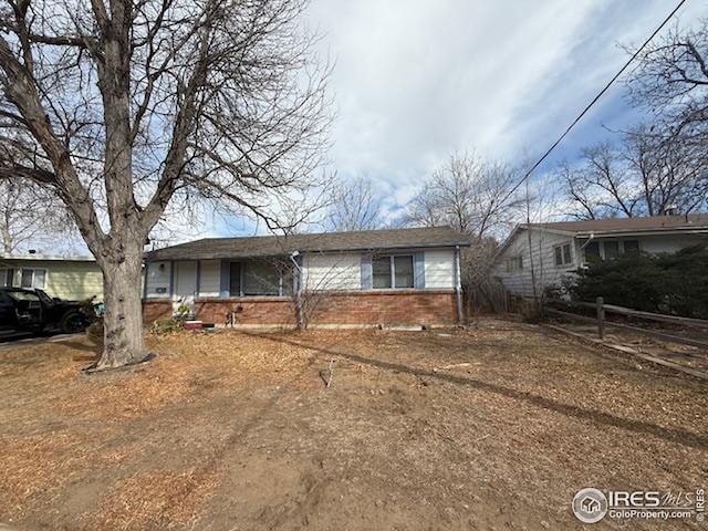 view of front of home featuring brick siding and fence