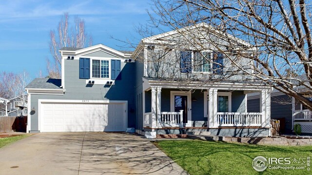 traditional-style house featuring a front lawn, a porch, concrete driveway, and a garage