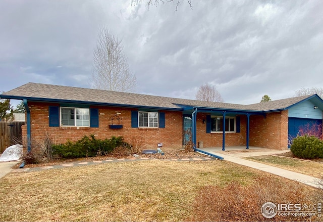 ranch-style home featuring a garage, a front yard, brick siding, and fence