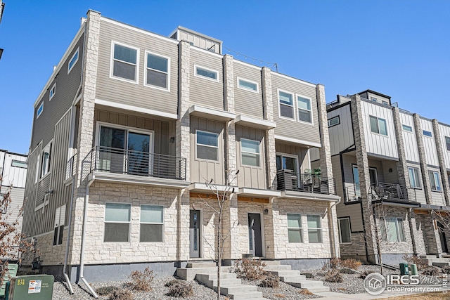 townhome / multi-family property featuring board and batten siding and stone siding
