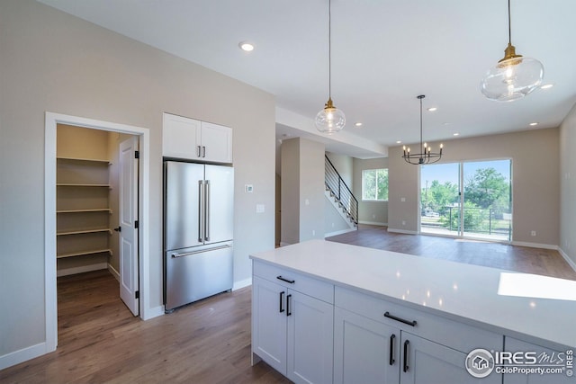 kitchen featuring light wood-style flooring, white cabinetry, pendant lighting, high end fridge, and recessed lighting