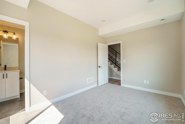 unfurnished bedroom featuring carpet, visible vents, and baseboards