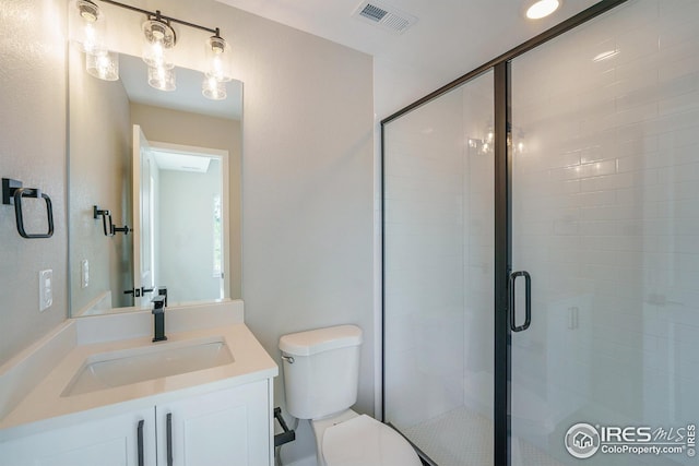 full bath with toilet, a shower stall, visible vents, and vanity