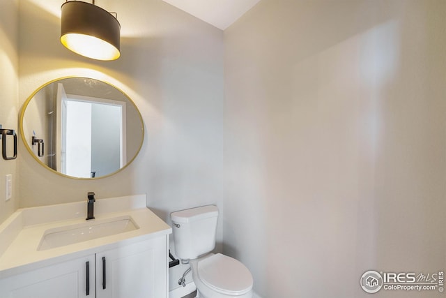 half bath featuring vanity and toilet