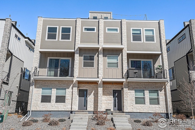 multi unit property featuring stone siding, board and batten siding, and a balcony