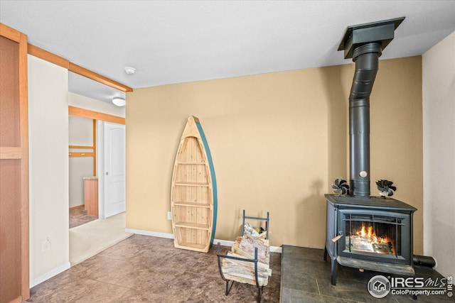 living area with a wood stove and baseboards