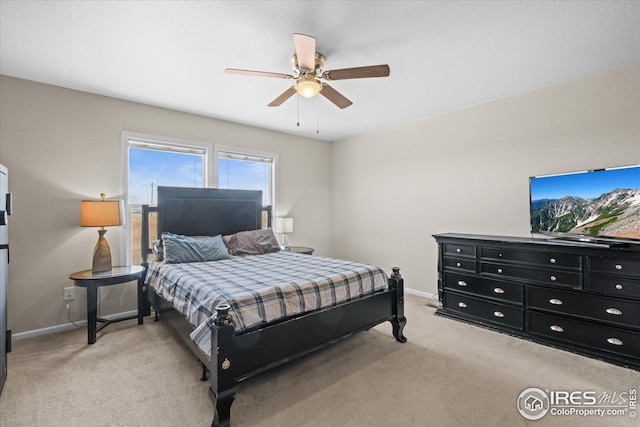 bedroom featuring baseboards, ceiling fan, and light colored carpet