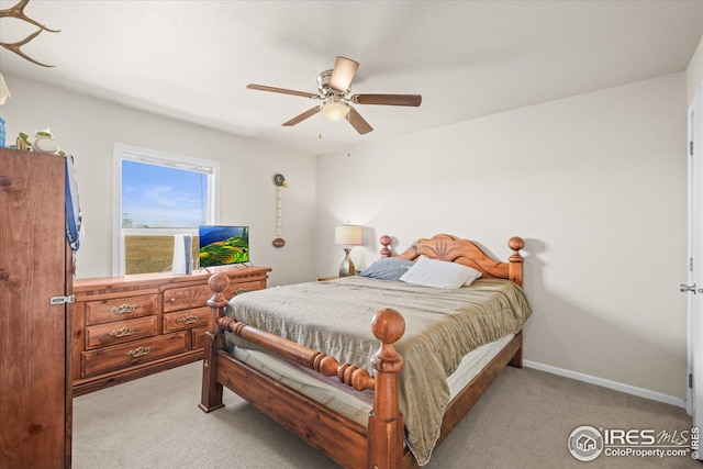 bedroom featuring ceiling fan, baseboards, and light colored carpet