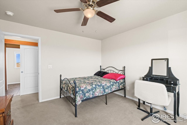 carpeted bedroom with ceiling fan and baseboards