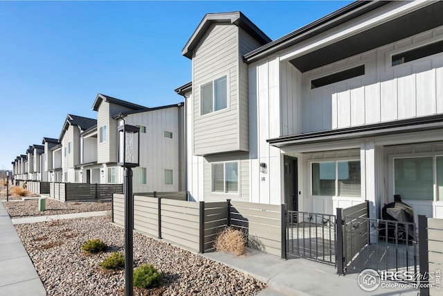 view of front of property featuring a fenced front yard, a residential view, and board and batten siding