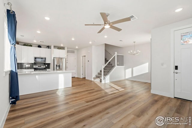 kitchen with stainless steel appliances, light wood-type flooring, visible vents, and white cabinets