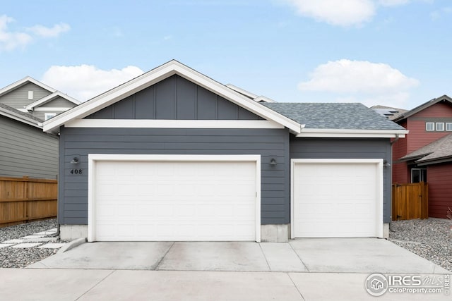 view of front of house featuring an attached garage, fence, concrete driveway, and roof with shingles