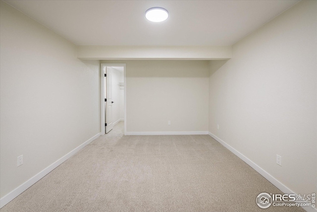 finished basement featuring light colored carpet and baseboards