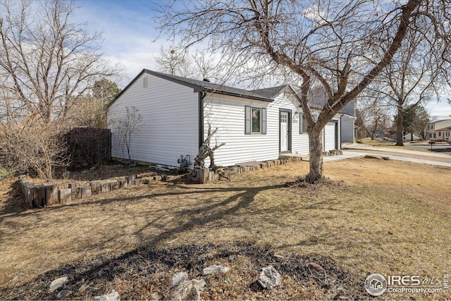 view of side of home with a garage and a yard