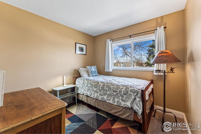 carpeted bedroom featuring baseboards