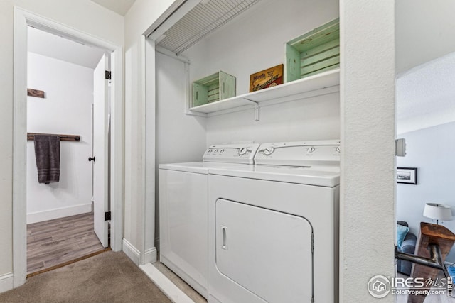 laundry area with baseboards, light colored carpet, laundry area, light wood-style floors, and washer and dryer