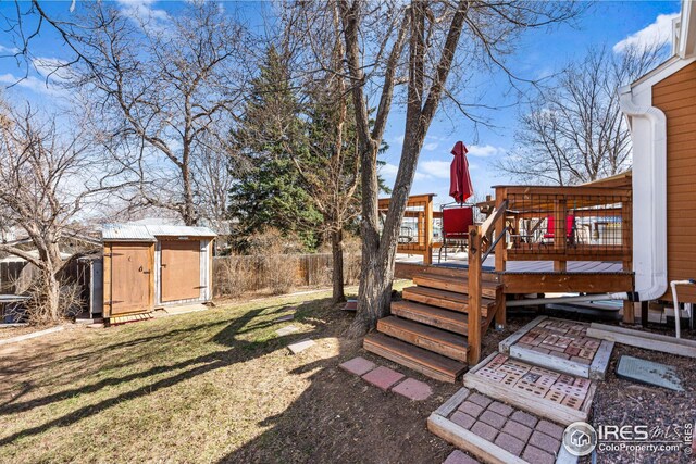 rear view of property with a yard, stairway, a wooden deck, and a fenced backyard