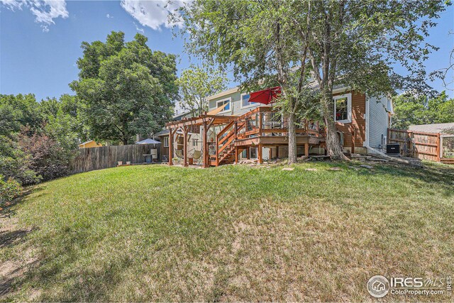 rear view of house with a yard, a wooden deck, a fenced backyard, and a pergola