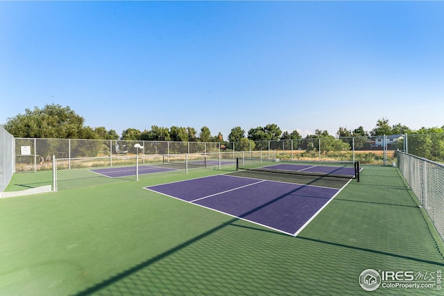 view of tennis court featuring fence