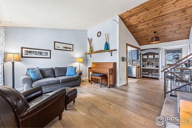 living area featuring wood finished floors, stairs, and vaulted ceiling