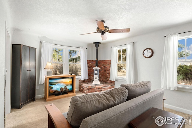 living area featuring a healthy amount of sunlight, light carpet, and a textured ceiling