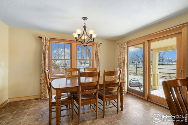 dining area with baseboards and a notable chandelier