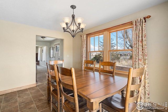 dining space featuring baseboards and an inviting chandelier